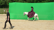 Before - riding in front of a green screen which has a background superimposed onto it during post production.